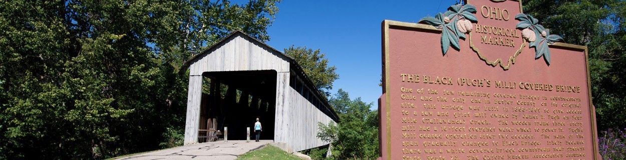 Woman Walking through Black Covered Bridge in Oxford, Ohio.